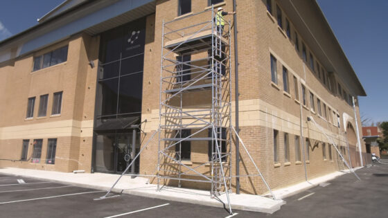 Construction crew using a mobile scaffold for exterior work